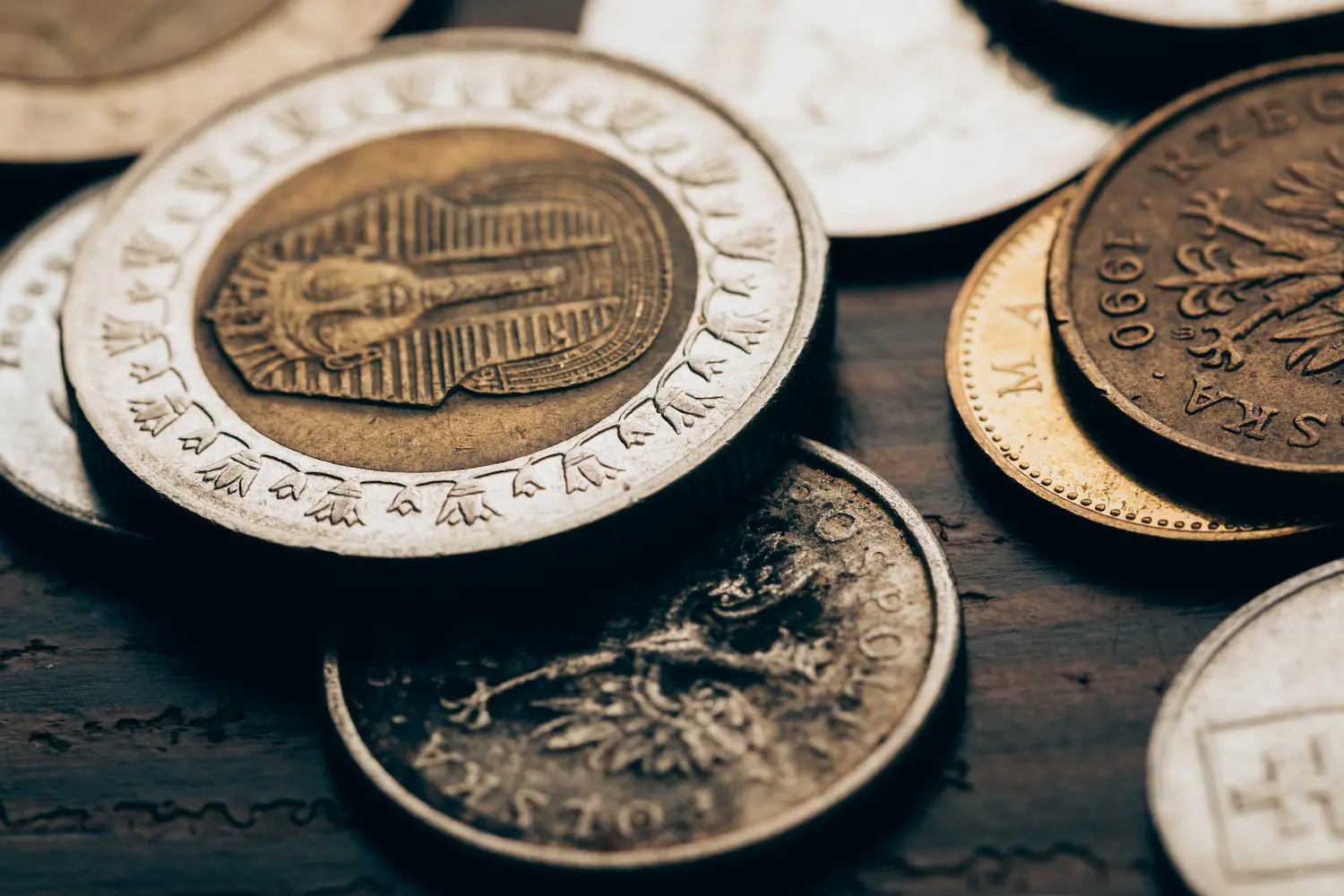 close-up-of-collection-of-different-coins-on-woode-2024-11-19-11-58-05-utc.webp